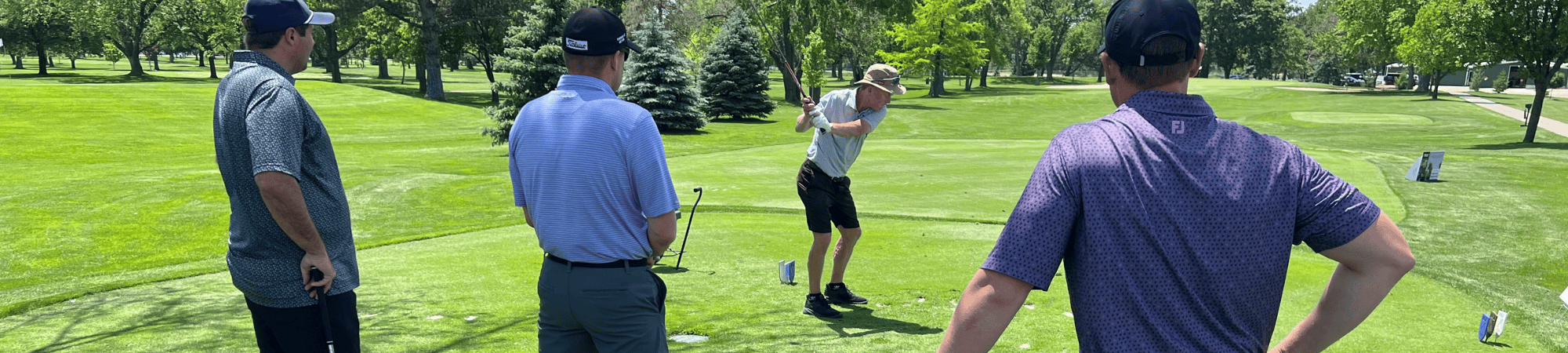 Golfers watch as a team member drives during the 38th Annual Heartland United Way Golf Tournament.