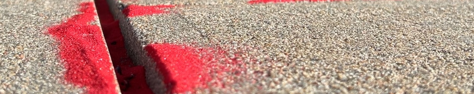 Red sand lined the sidewalk cracks in front of the Heartland United Way as a way to raise awareness of trafficking.